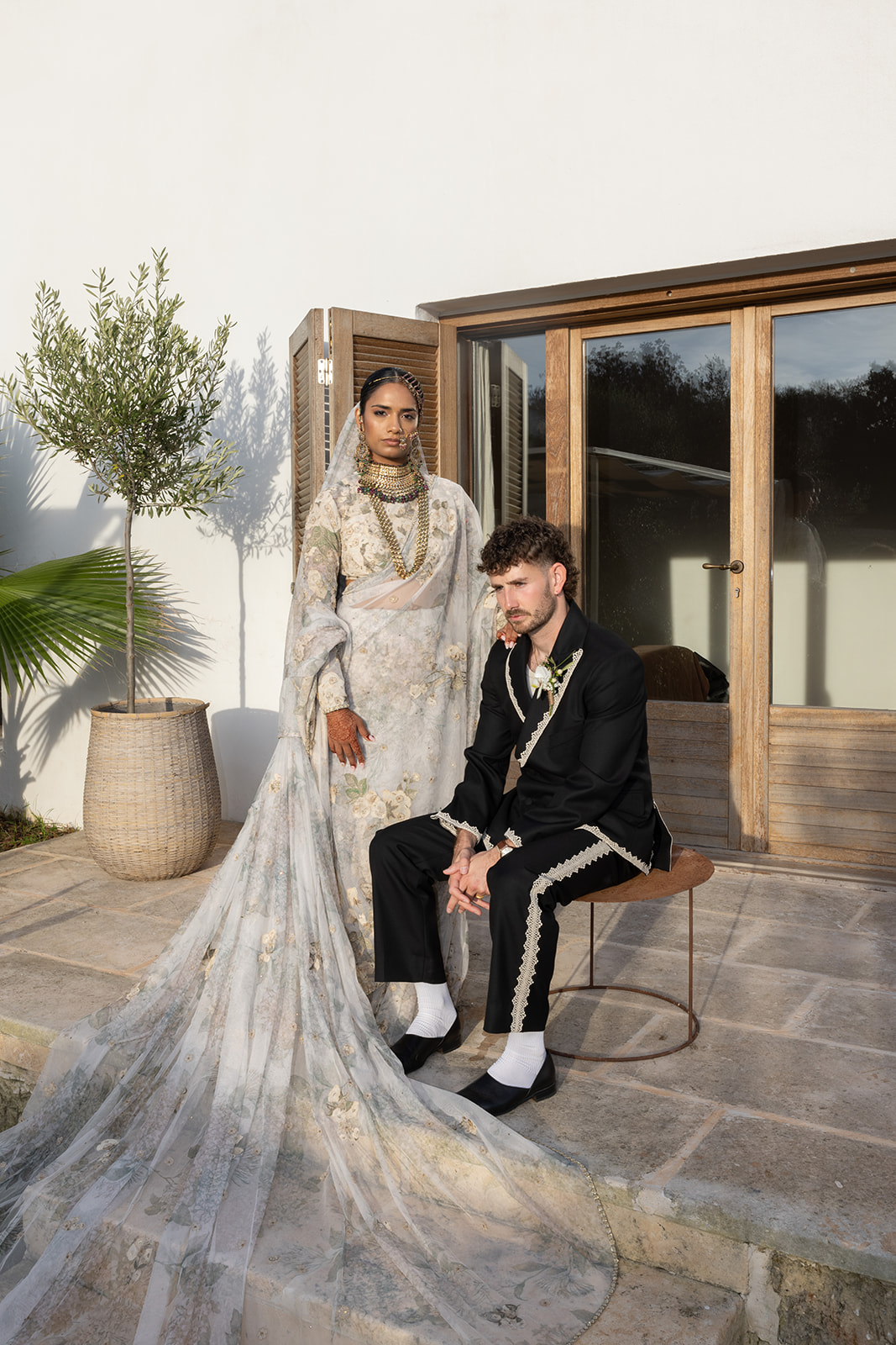 Bride and groom at Amagatay Menorca, standing outside a modern villa during golden hour — a serene moment captured by Menorca wedding photographer Sus Pons.